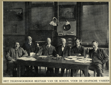 105933 Groepsportret van het bestuur van de School voor de Grafische Vakken. Ten voeten uit, zittend aan een tafel. Van ...